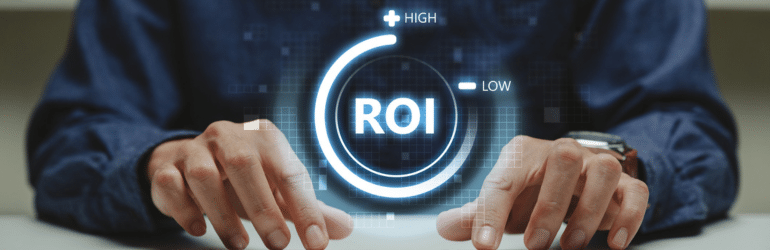 Young business pointing to ROI on laptop screen.